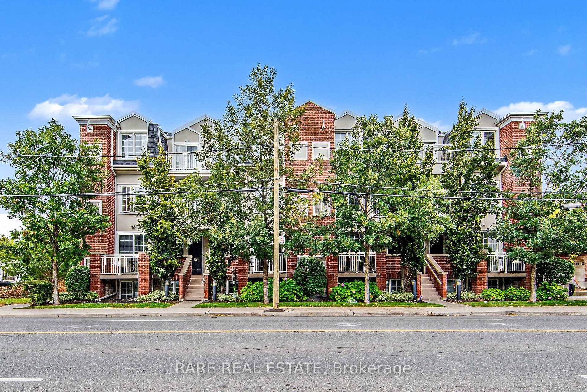 2320 Gerrard Street East, red-brick stacked townhome complex from the street